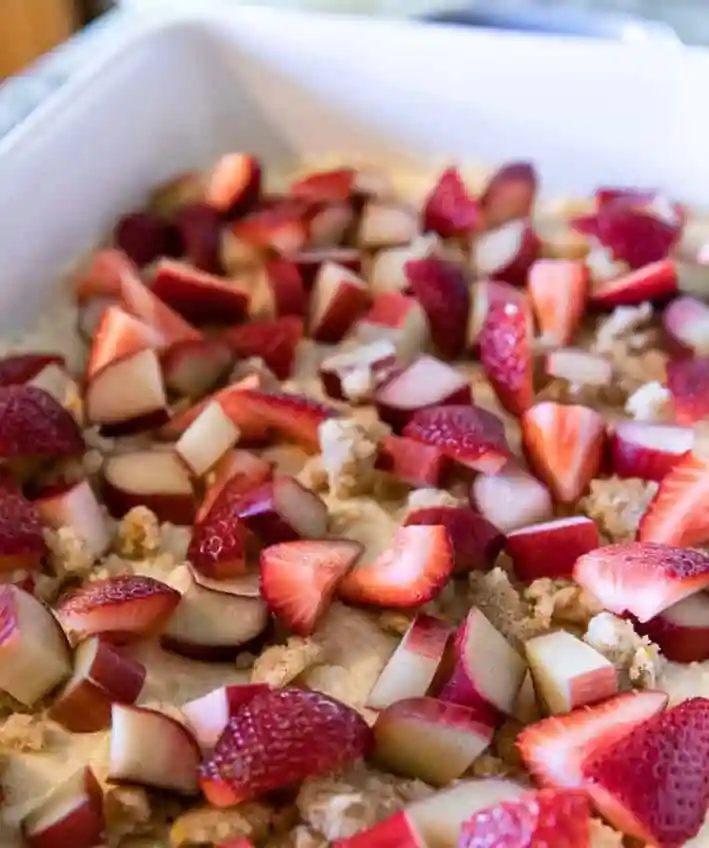 Erdbeer Rhabarber Kuchen vom Blech vor dem Backen – Teig mit Erdbeeren und Rhabarber für einen Blechkuchen