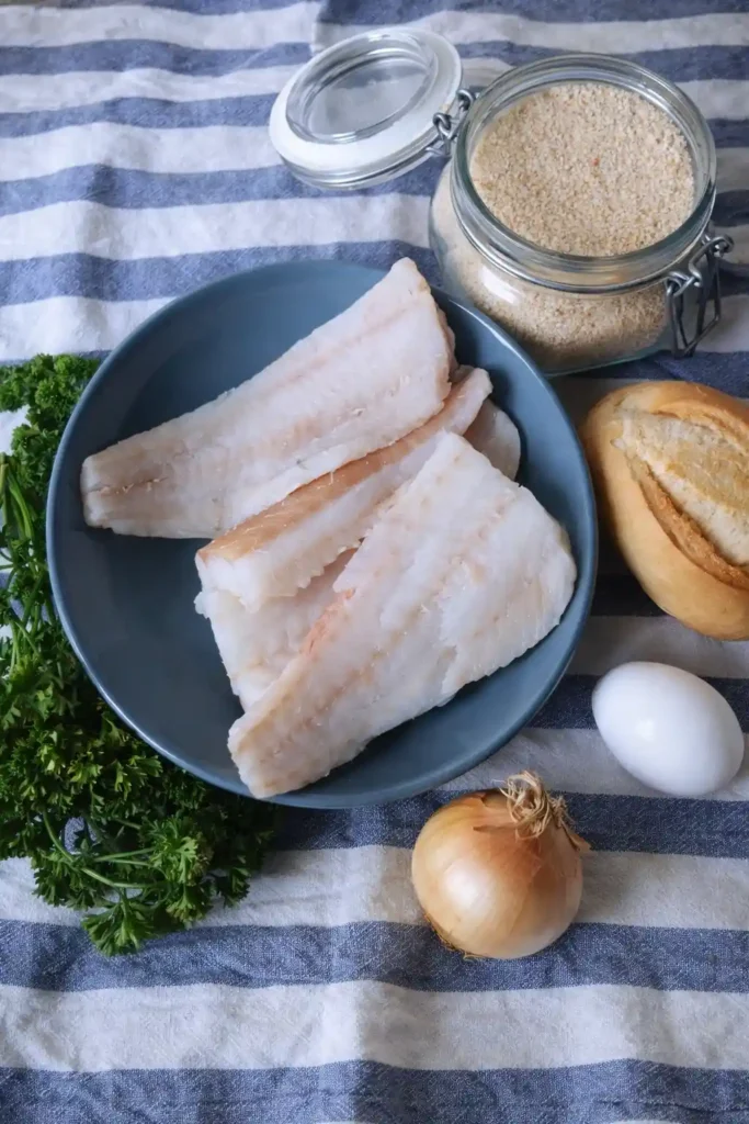 Zutaten für Fischfrikadellen Rezept DDR mit Kabeljau, Brötchen, Ei, Zwiebel und Petersilie
