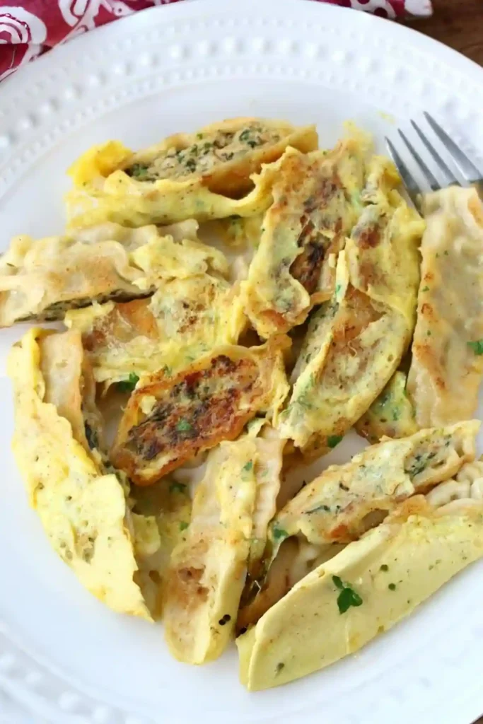 Gebratene Maultaschen Pfanne mit Ei auf einem Teller – knusprig angebratene Maultaschen mit Ei aus der Pfanne