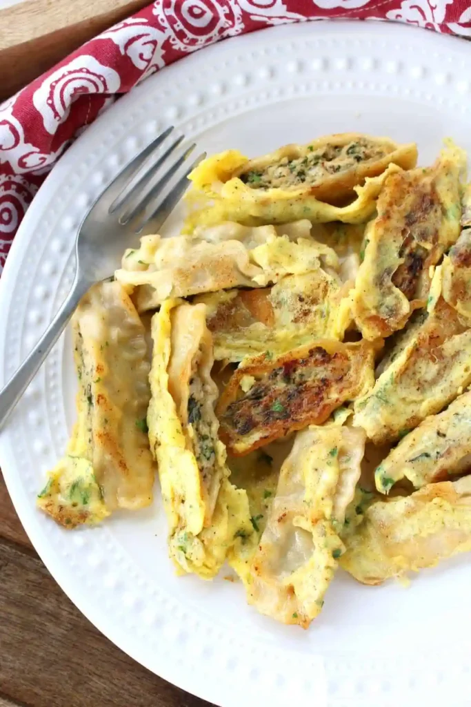 Gebratene Maultaschen Pfanne mit Ei auf einem Teller – knusprig angebratene Maultaschen mit Ei und Kräutern