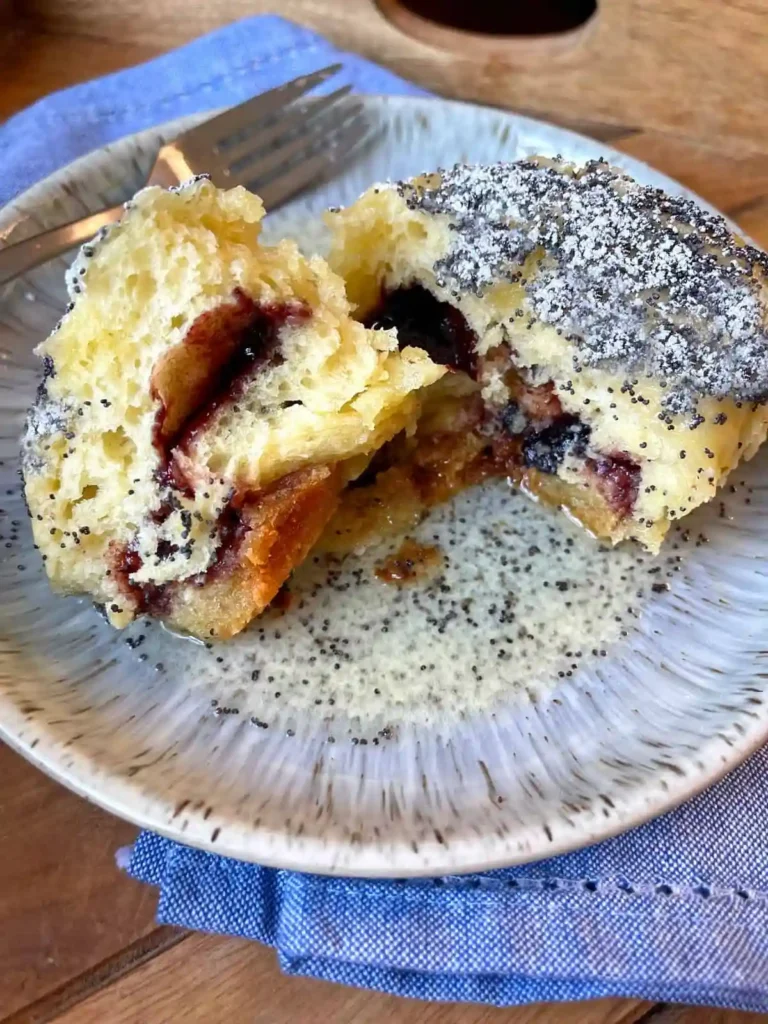 Germknödel mit Pflaumenmus angeschnitten – fluffiger Germknödel mit Mohn und Puderzucker