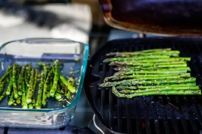 Grüner Spargel grillen auf dem Grillrost – gegrillter Spargel vom Grill mit Marinade