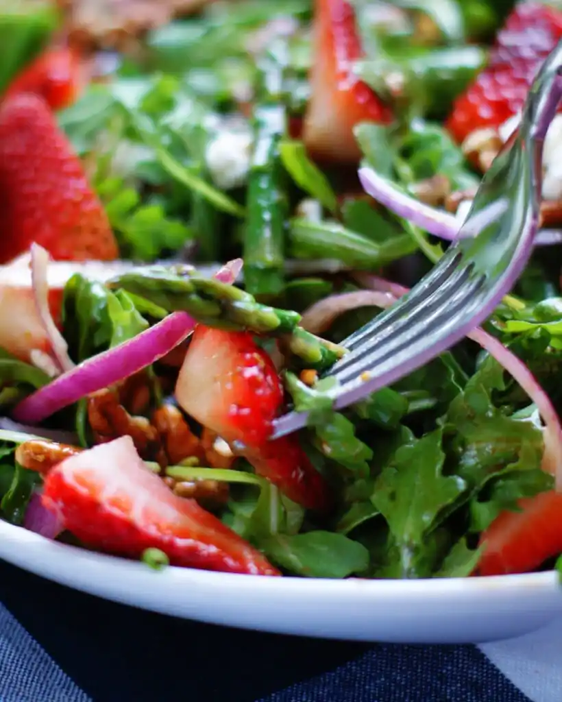 Gabel mit grüner spargelsalat mit erdbeeren und balsamico mit spargel, erdbeeren und rucola