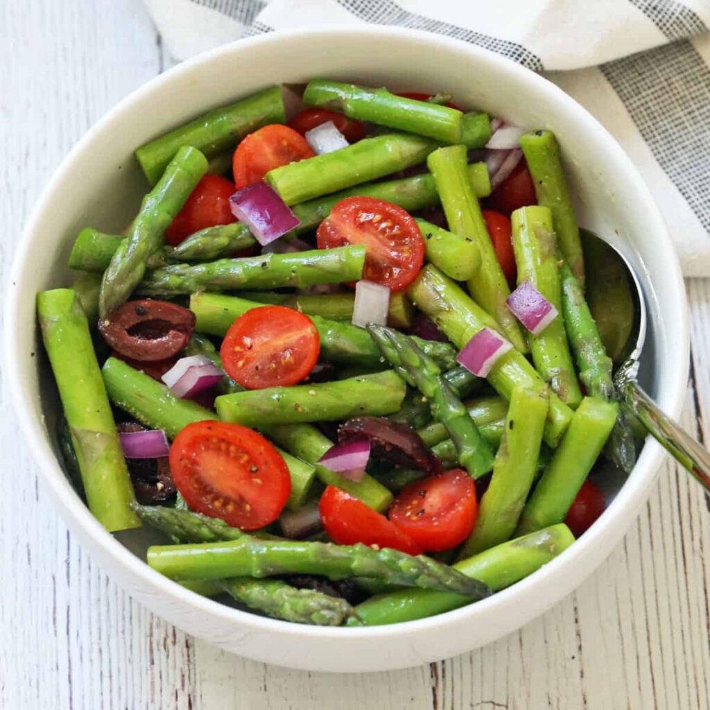 Grüner Spargelsalat Rezept klassisch mit Essig und Öl, Tomaten, Oliven und roten Zwiebeln – einfacher Spargelsalat
