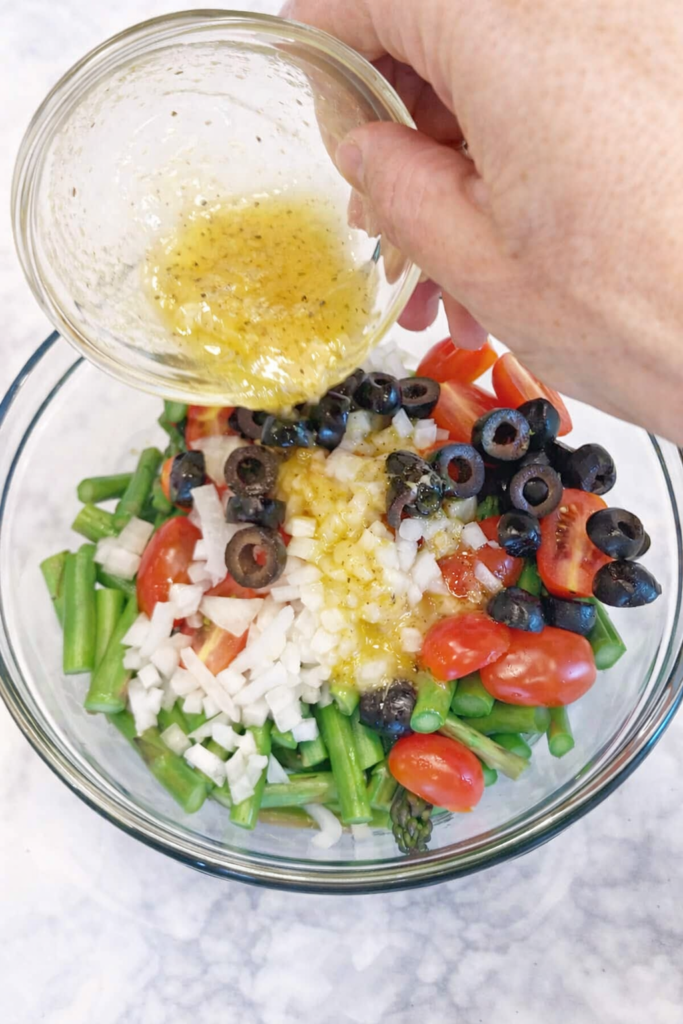 Spargelsalat Dressing mit Essig und Öl über grüner Spargelsalat gießen – klassisches Spargelsalat Rezept