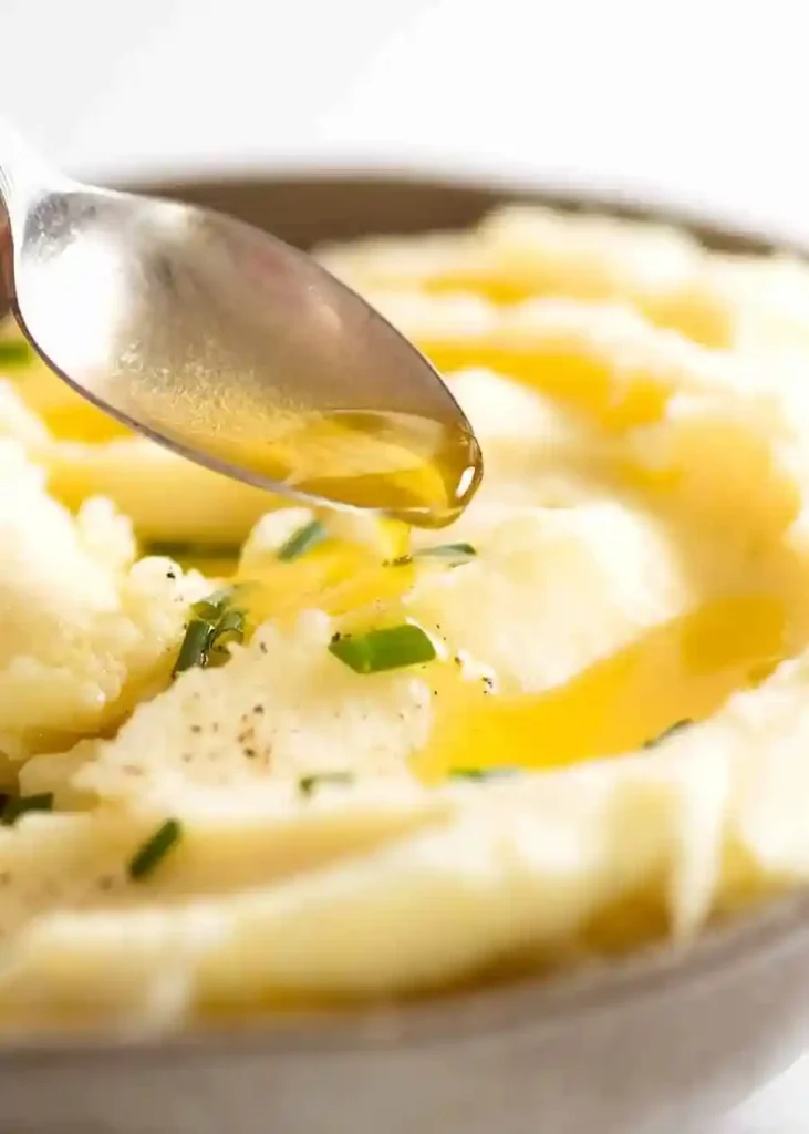 Butter wird über cremiges Kartoffelpüree gegossen – klassisches Kartoffelpüree Rezept zum Kartoffelpüree selber machen