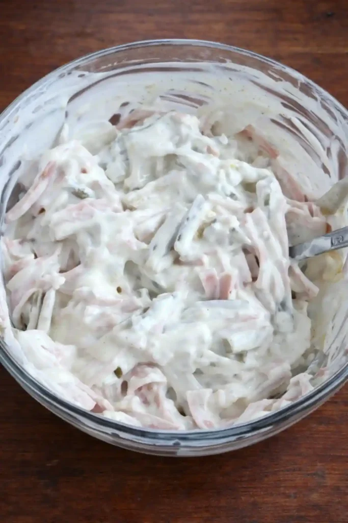 Fleischsalat selbst gemacht mit mayonnaise in einer Schüssel cremig vermischt