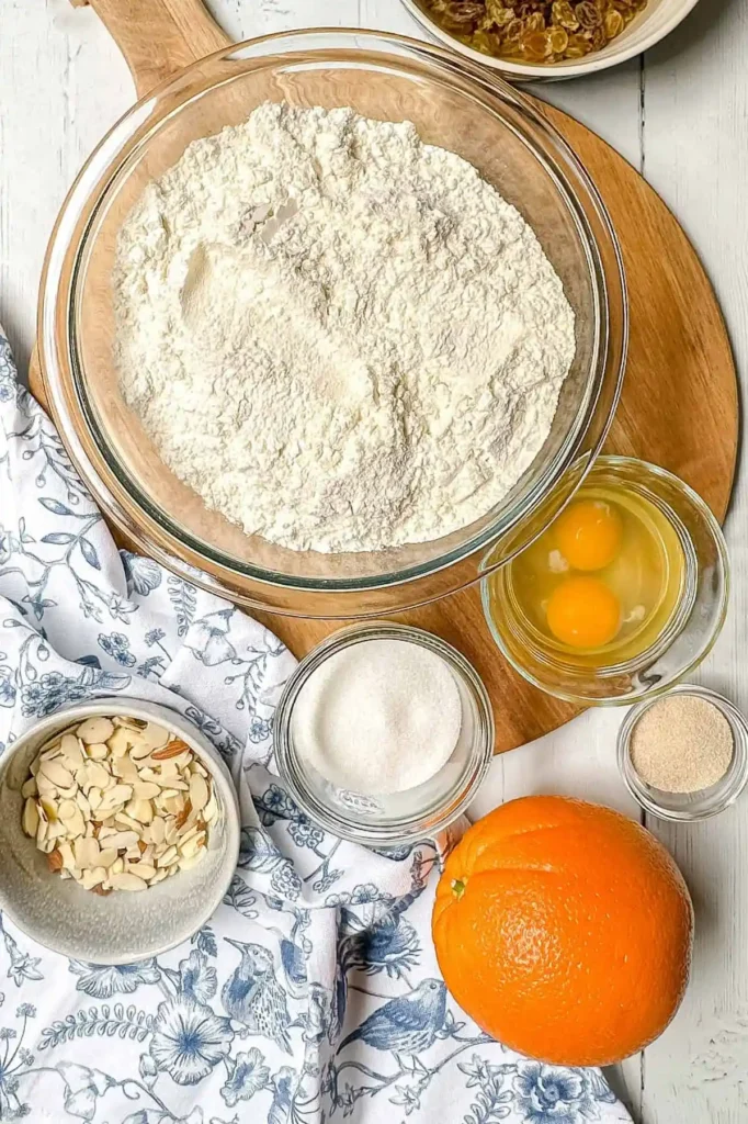 Zutaten für Osterbrot Rezept mit Trockenhefe – Mehl, Eier, Zucker, Rosinen, Orange und Mandelblättchen für Omas Osterbrot