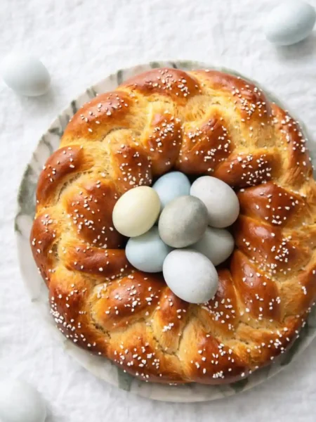 Osterkranz Rezept aus Hefeteig – frisch gebackener Osterkranz mit Hagelzucker und bunten Ostereiern in der Mitte wie Omas Osterkranz zum Osterbrunch