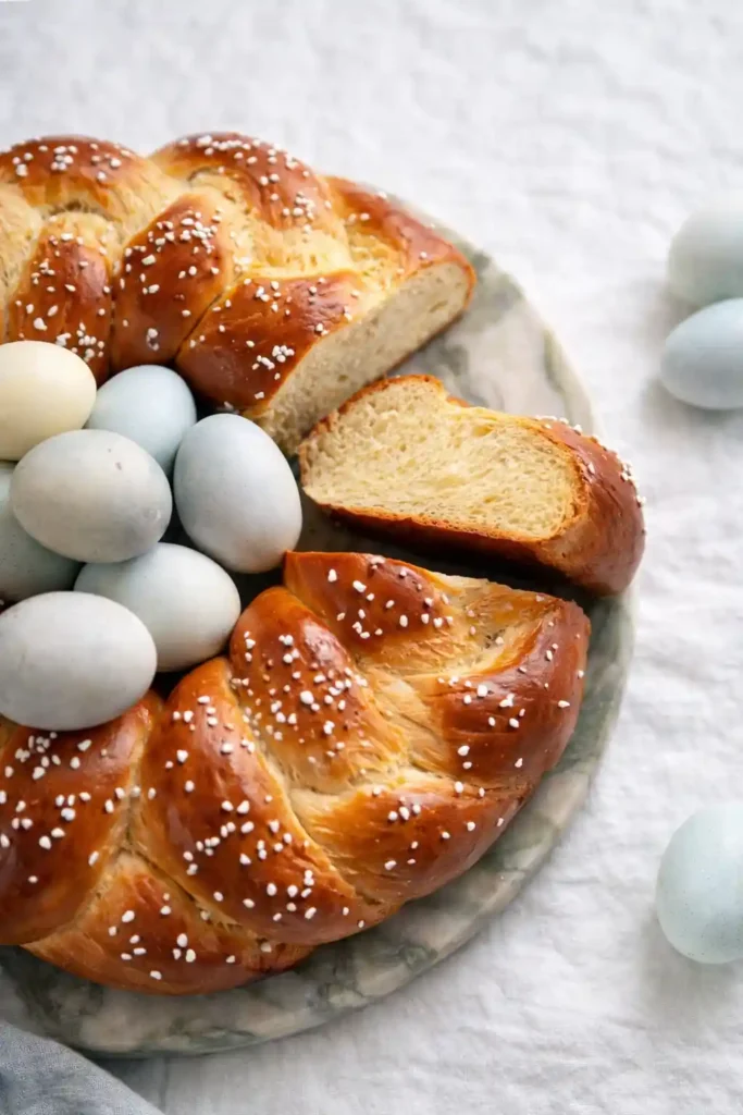 Osterkranz Rezept aus Hefeteig – aufgeschnittener Osterkranz mit Hagelzucker und bunten Ostereiern, fluffiger Hefeteig wie bei Omas Osterkranz