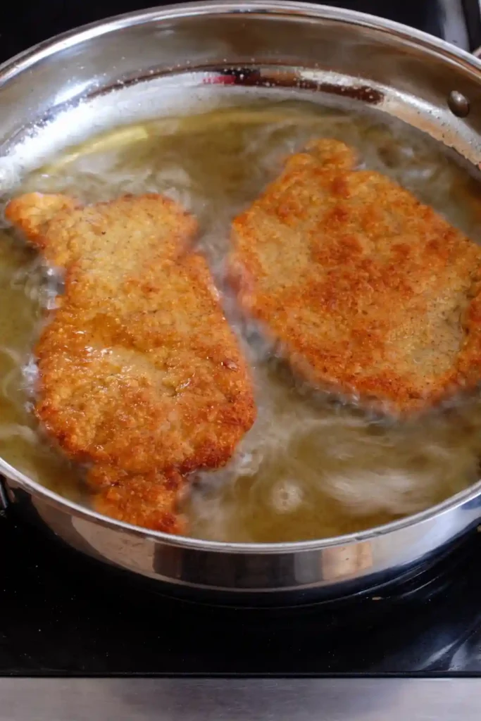 Panierte Schnitzel in der Pfanne braten – letzter Schritt im Schnitzel Rezept nach der Schnitzel panieren Reihenfolge