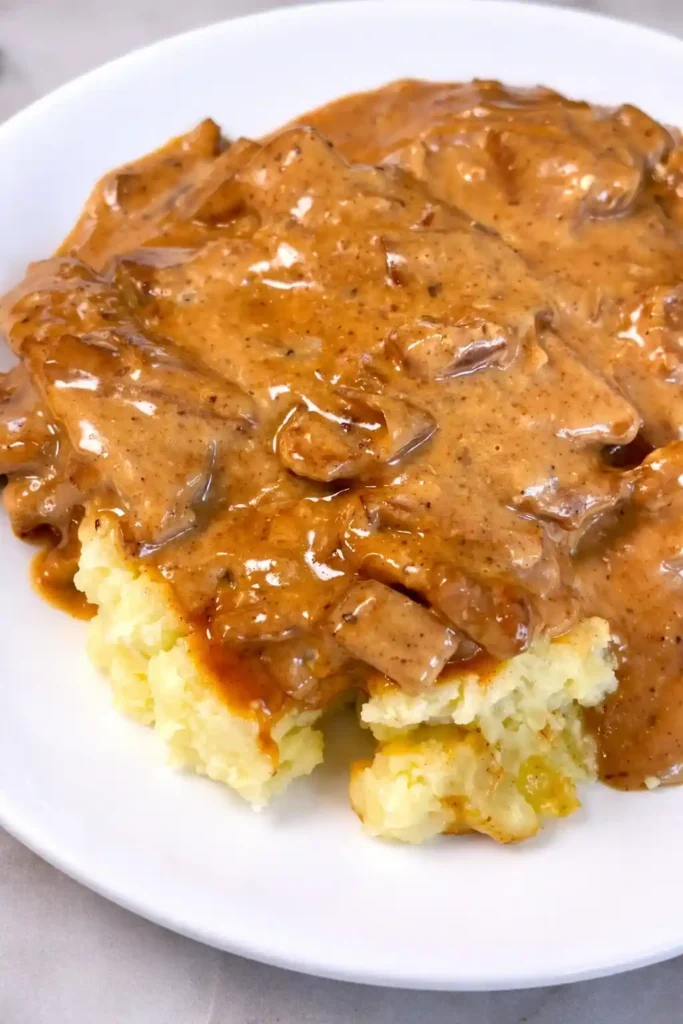 Schweinegeschnetzeltes mit pilzen und rahmsauce serviert mit Kartoffelpüree