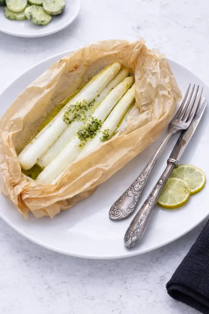 Spargel im Backpapier im Ofen gegart auf Teller – weißer Spargel im Backofen zubereiten Rezept
