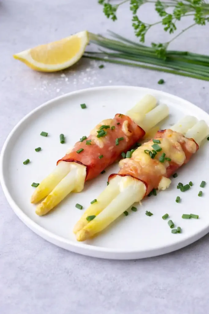 Spargel überbacken mit Schinken und Käse auf Teller – Spargel Schinkenröllchen serviert