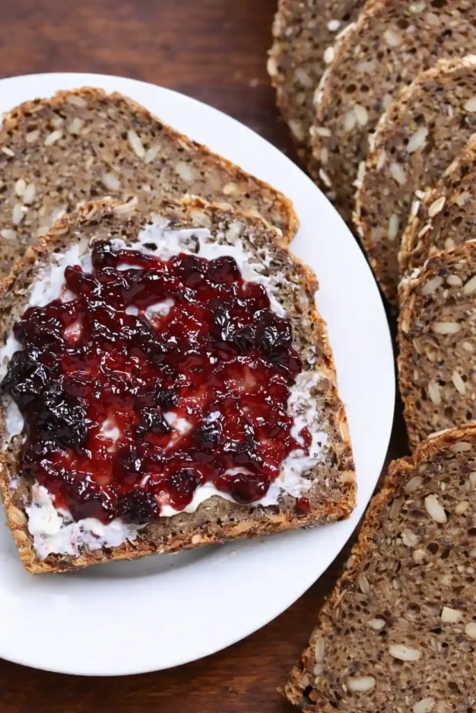 Saftiges Vollkornbrot mit Trockenhefe selber backen – Scheibe Vollkornbrot mit Frischkäse und Marmelade