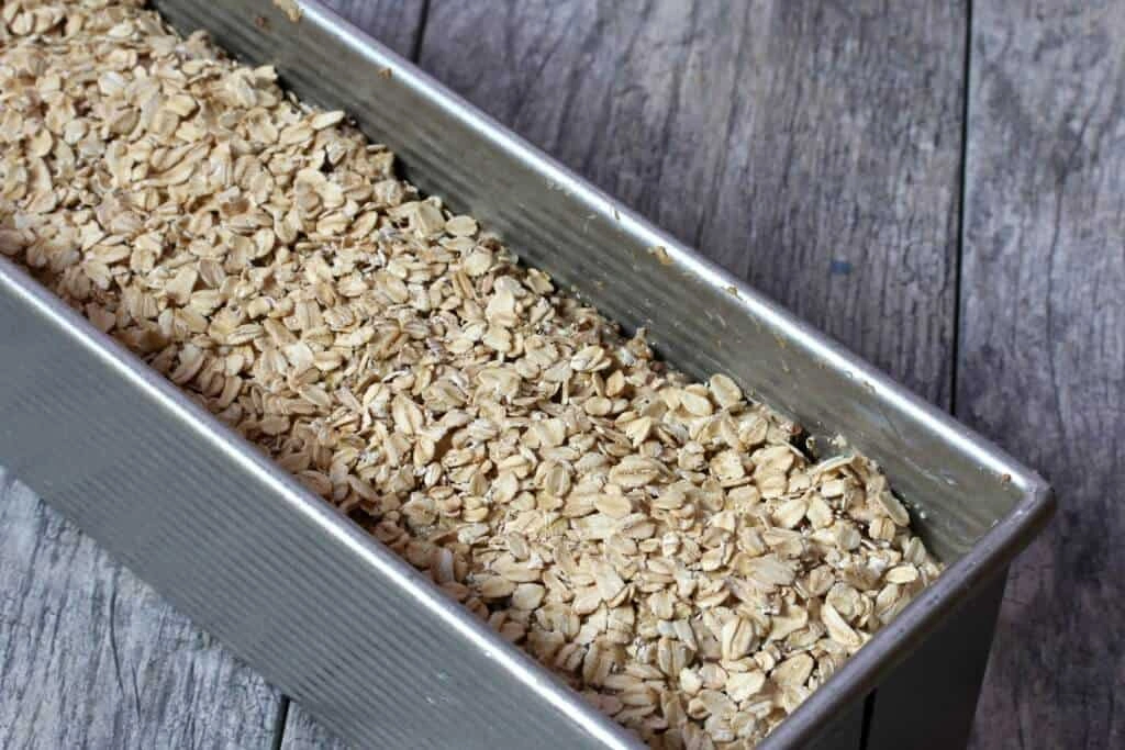 Vollkornbrot Teig mit Haferflocken bestreut in Kastenform – Vollkornbrot mit Trockenhefe backen