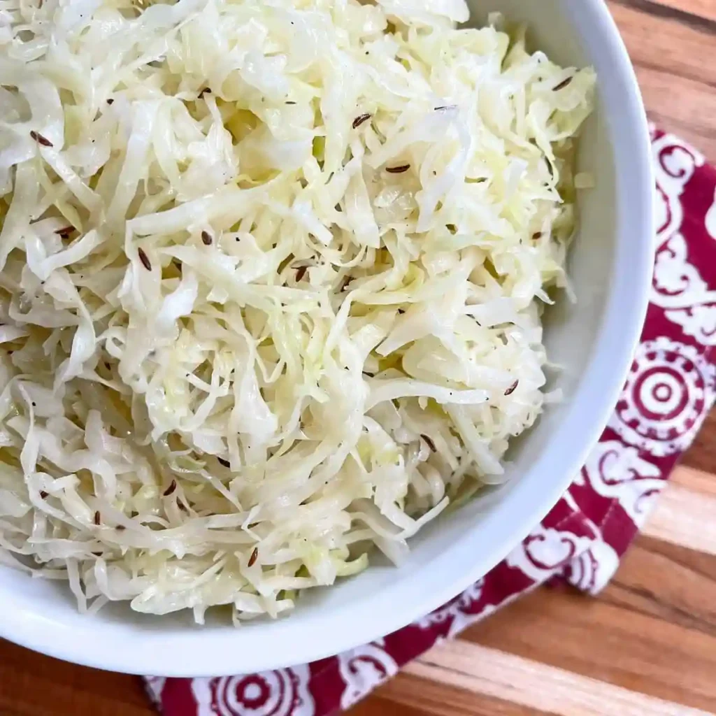 Weißkrautsalat Rezept Nahaufnahme – klassischer Krautsalat mit Kümmel im weißen Teller