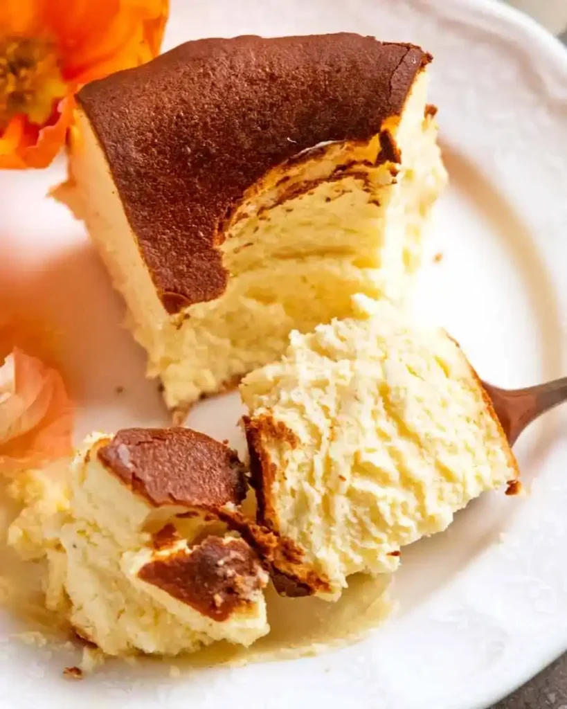 Stück baskischer Käsekuchen original Rezept auf dem Teller mit cremiger Mitte wie ein echter San Sebastian Cheesecake