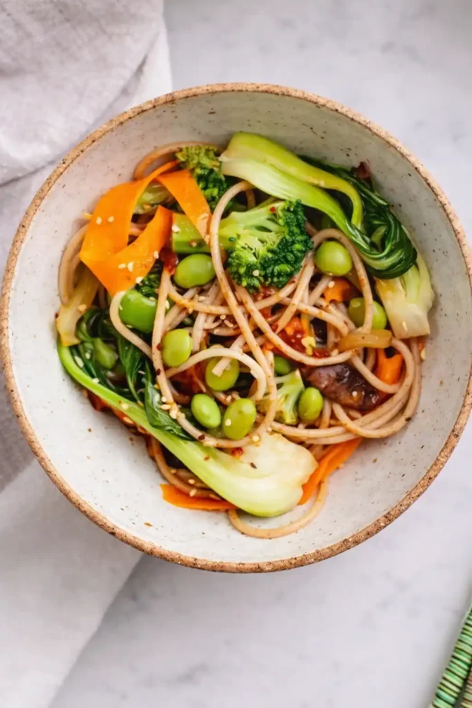 Pak Choi Pfanne mit Gemüse und Nudeln in einer Schüssel, asiatisches Rezept mit Brokkoli, Karotten und Edamame