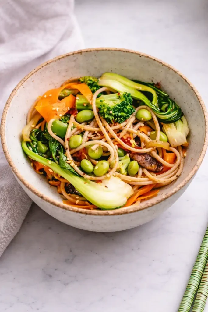 Pak Choi Pfanne mit Gemüse und Nudeln in einer Schüssel, asiatisches Rezept mit Brokkoli, Karotten und Edamame