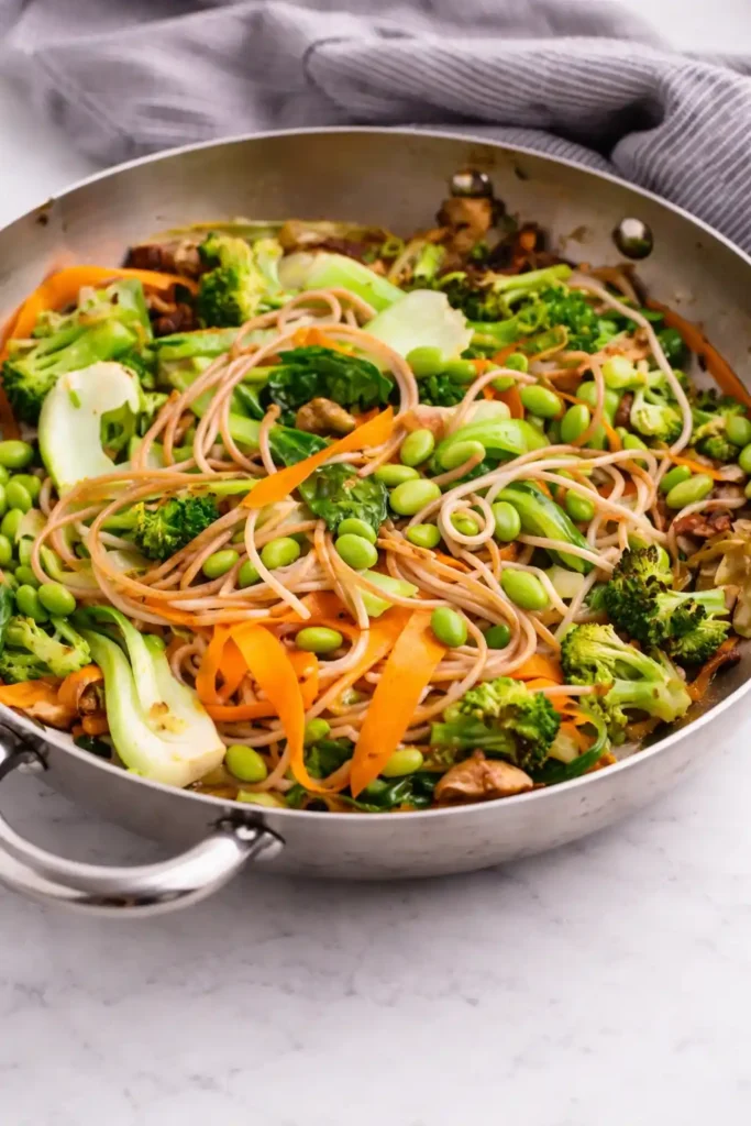 Pak Choi Pfanne mit Gemüse und Nudeln in der Pfanne, asiatisches Rezept mit Brokkoli, Karotten und Edamame