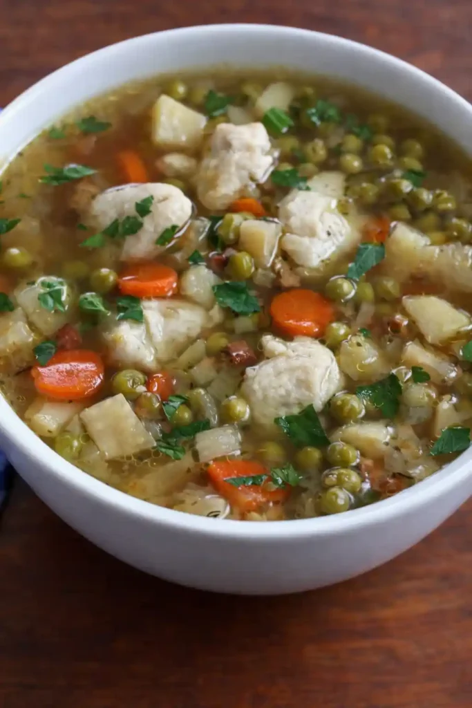 Erbsensuppe Rezept wie Oma mit Eierschwämmchen, Kartoffeln, Möhren und Erbsen in einer Schüssel
