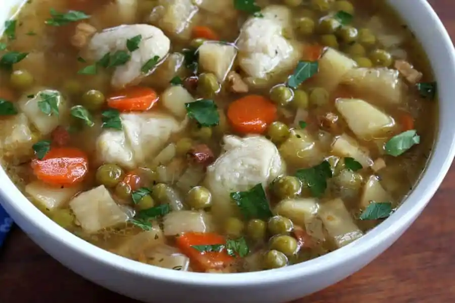 Erbsensuppe Rezept wie Oma mit Eierschwämmchen, Kartoffeln, Möhren und Erbsen in einer Schüssel