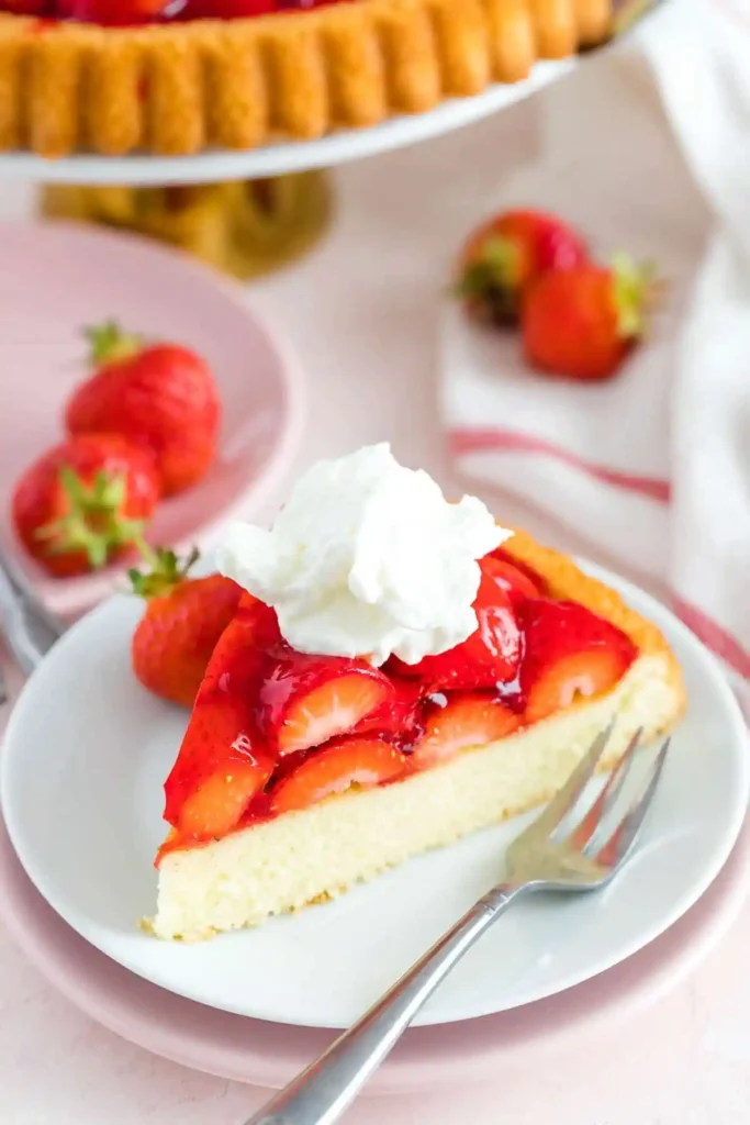 Stück Erdbeerboden mit Erdbeeren und Sahne – klassischer Tortenboden mit Erdbeeren wie bei Oma auf einem Teller serviert