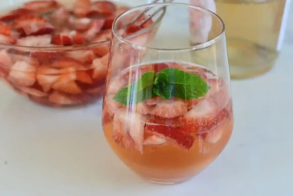 Erdbeerbowle klassisch mit Sekt und Weißwein im Glas, fruchtige Erdbeerbowle mit frischen Erdbeeren und Minze