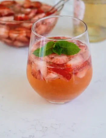 Erdbeerbowle klassisch mit Sekt und Weißwein im Glas, fruchtige Erdbeerbowle mit frischen Erdbeeren und Minze