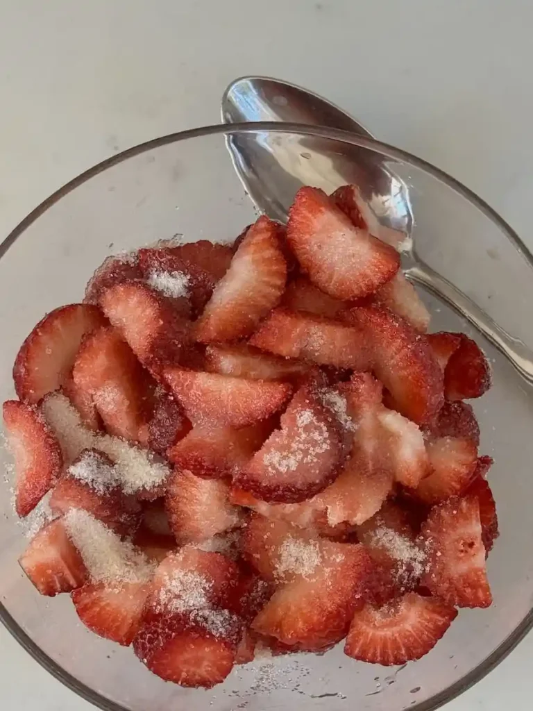 Erdbeerbowle vorbereiten mit frischen Erdbeeren und Zucker, Zutaten für Erdbeerbowle klassisch Rezept