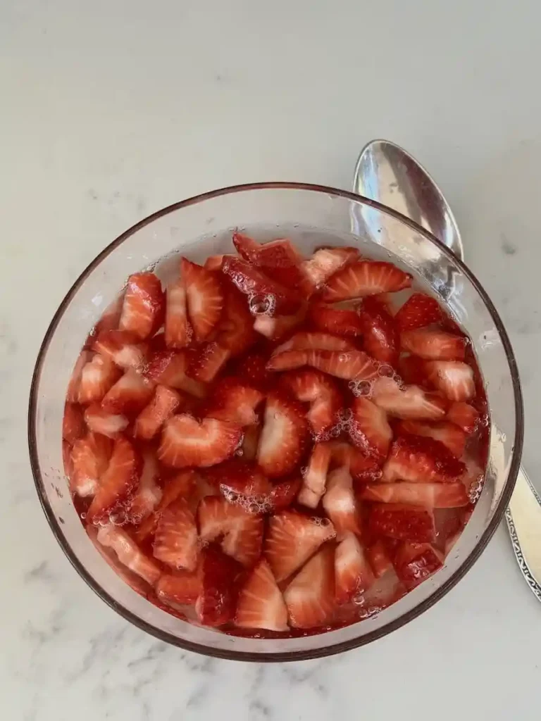 Erdbeerbowle vorbereiten mit Erdbeeren und Weißwein, klassische Erdbeerbowle Mischung im Glas