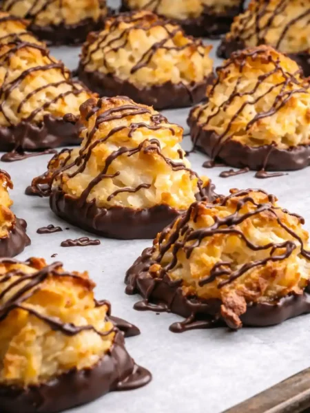 Kokosmakronen mit Schokolade nach Omas Rezept auf Backpapier – saftige kokosmakronen mit oblaten und schokoladenüberzug