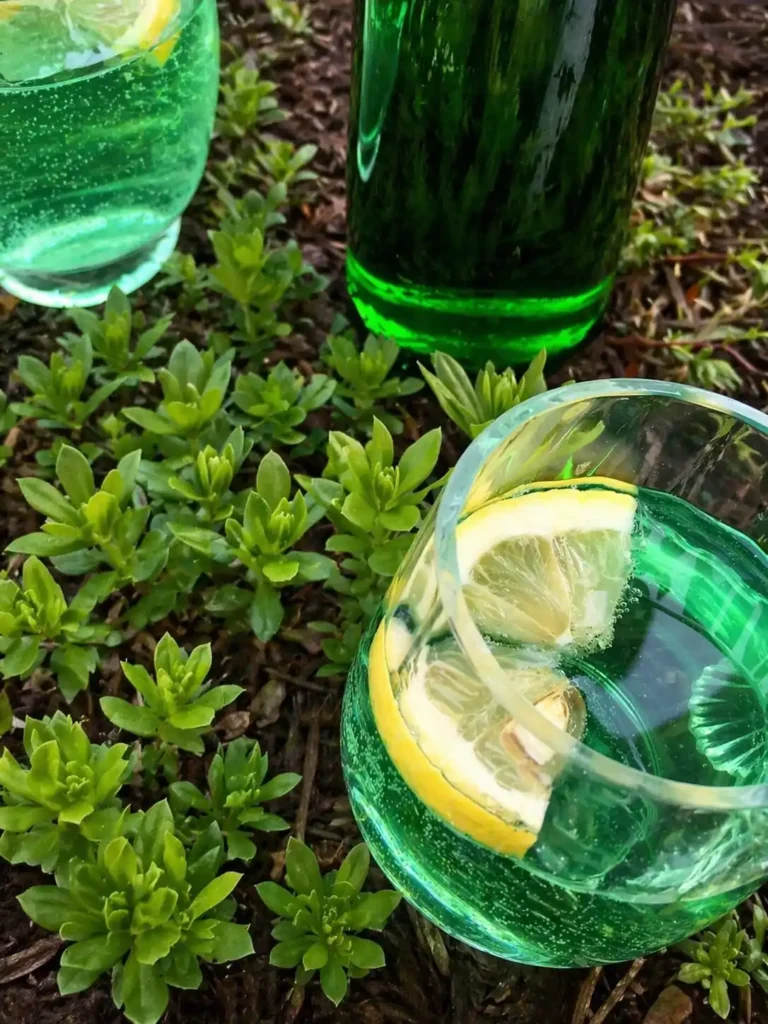 Maibowle alkoholfrei mit Zitrone im Glas als frische Waldmeisterbowle im Grünen
