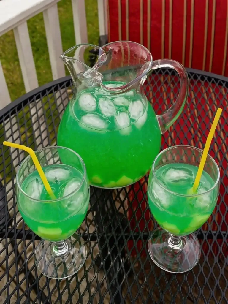 Maibowle alkoholfrei in Karaffe und Gläsern mit Eis und Ananas als frische Waldmeisterbowle für den Frühling