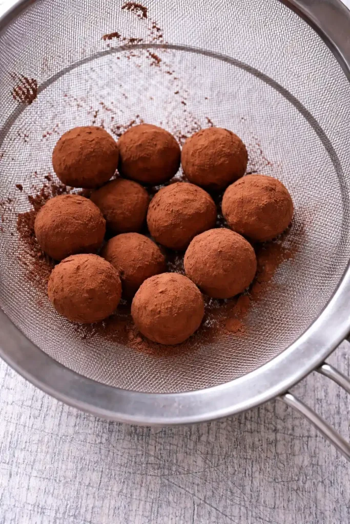 Marzipankartoffeln durch Sieb mit Kakao bestäuben – Marzipankartoffeln selber machen aus Mandeln