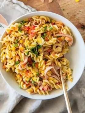 Nudelsalat mit Dressing klassisch wie bei Oma mit Fleischwurst, Eiern, Gemüse und cremiger Soße in einer Schüssel