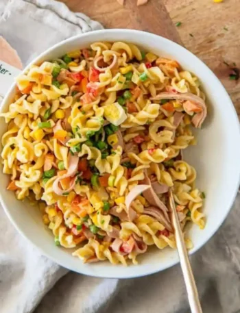 Nudelsalat mit Dressing klassisch wie bei Oma mit Fleischwurst, Eiern, Gemüse und cremiger Soße in einer Schüssel