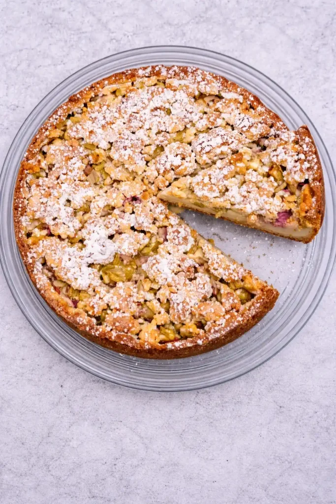Rhabarberkuchen mit Pudding und Streusel in Springform von oben – saftiger Rhabarberkuchen nach Omas Rezept angeschnitten