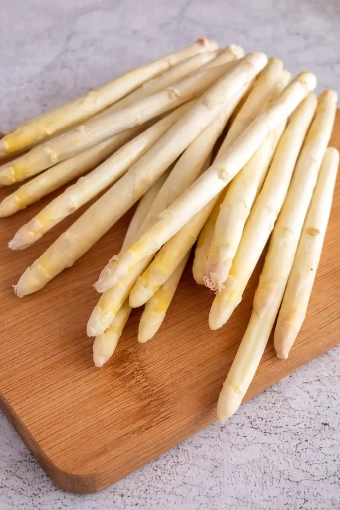 Weißer Spargel für Spargelsuppe mit Ei auf einem Brett – frische Zutat für Omas Spargelsuppe mit Ei