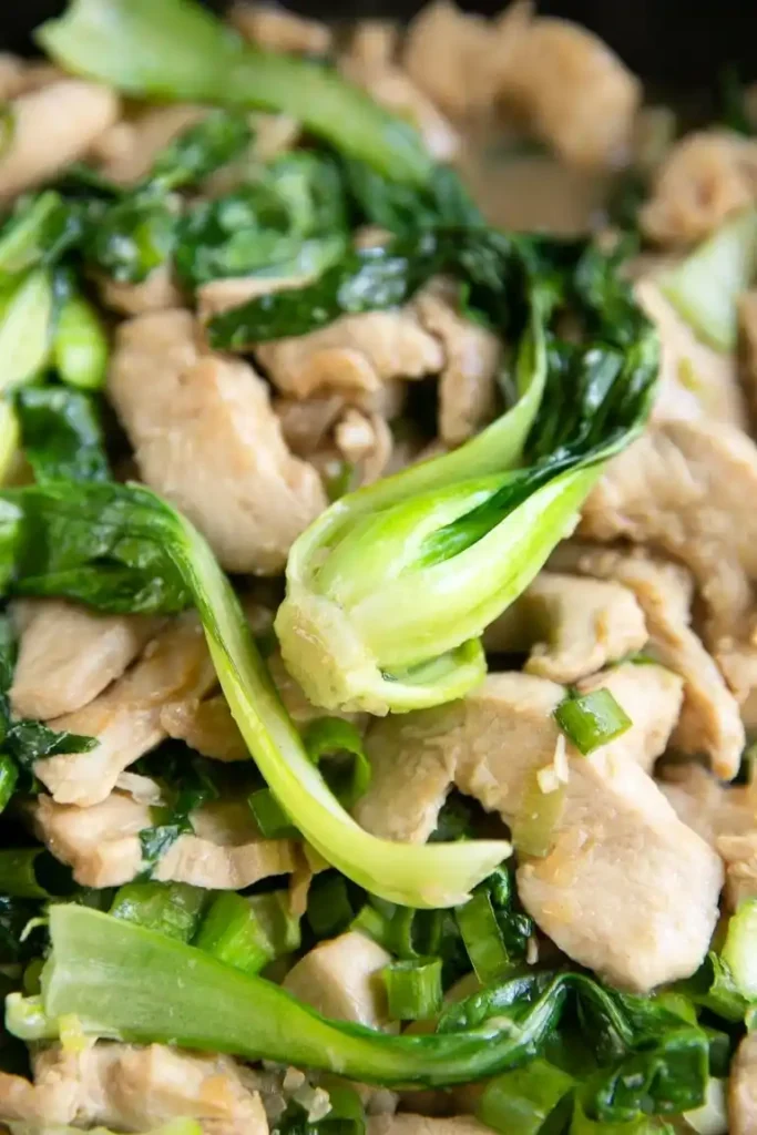 Nahaufnahme von Pak Choi mit Hähnchen – saftige Hähnchenbrust und zarter Pak Choi in der Pfanne