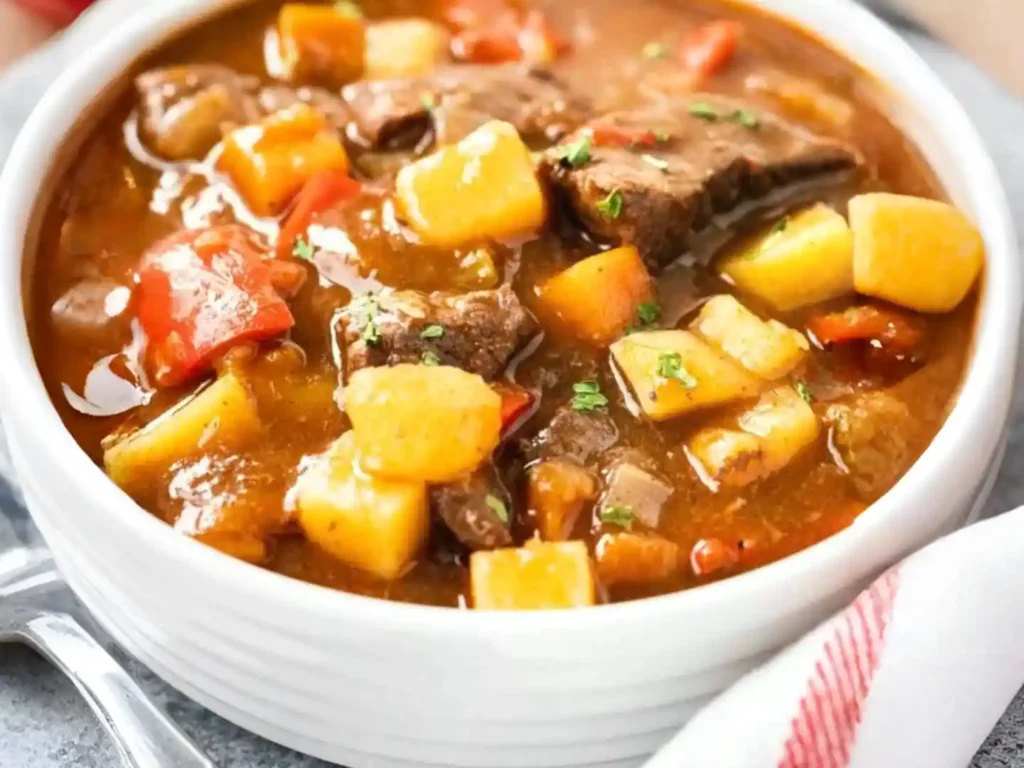 Ungarisches Gulasch Rezept original mit Paprika und Kartoffeln – klassisches ungarisches Rindergulasch in Schüssel serviert