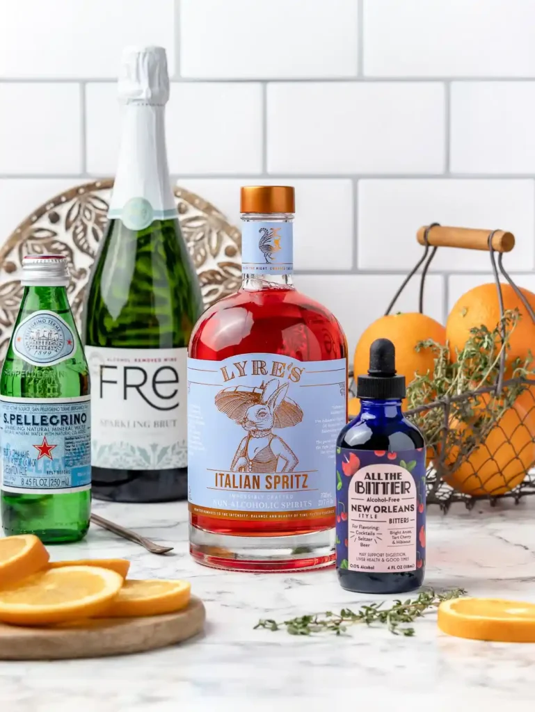 Zutaten für Aperol Spritz ohne Alkohol mit alkoholfreiem Aperol, alkoholfreiem Sekt, Mineralwasser, Orange und Bitter