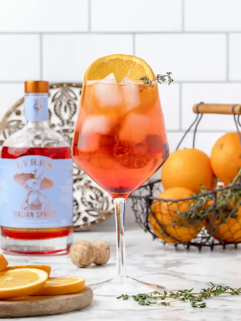 Aperol Spritz ohne Alkohol im Weinglas mit Orangenscheibe, Eiswürfeln, alkoholfreiem Aperol und Sprudel