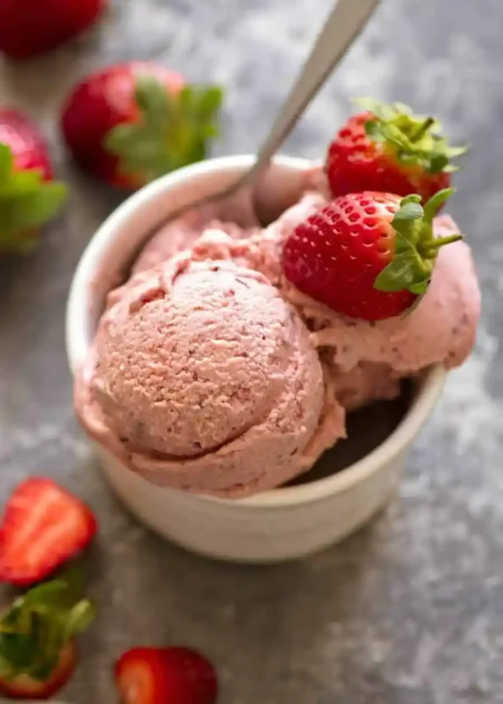 Cremiges Erdbeereis ohne Eismaschine in einer Schale mit frischen Erdbeeren serviert