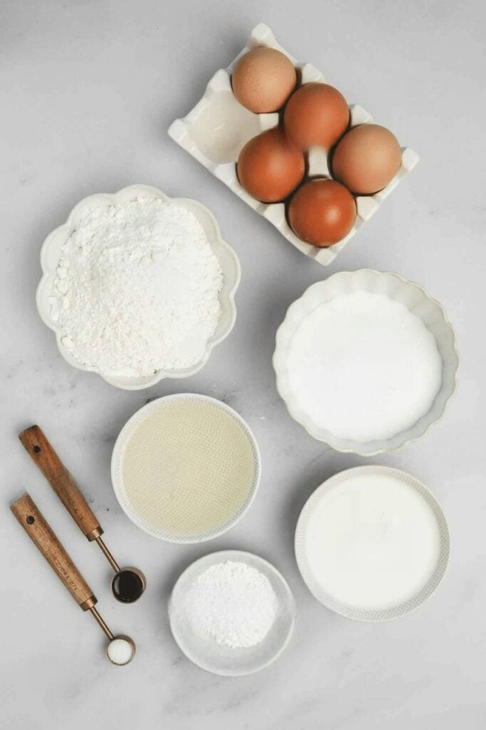 Zutaten für Erdbeertorte mit Sahne mit Eiern, Mehl, Zucker, Milch, Öl und Vanille für eine einfache Erdbeer-Sahne-Torte