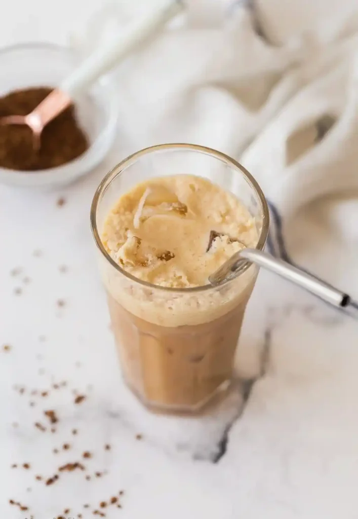 Café Frappé von oben mit Eiswürfeln, cremigem Kaffeeschaum und Instantkaffee