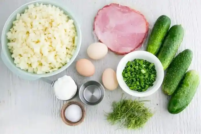 Okroschka Zutaten für russische kalte Suppe mit Kartoffeln, Gurken, Eiern, Schinken, Dill und Frühlingszwiebeln