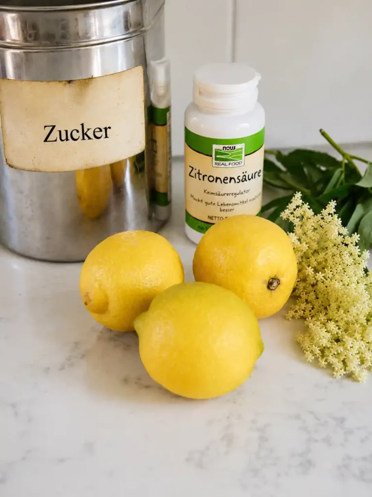Zutaten für Omas Holunderblütensirup Rezept mit Zitronen, Holunderblüten, Zucker und Zitronensäure
