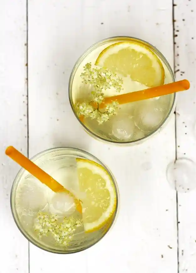 Holunderblütensirup Rezept mit Zitronen, Eiswürfeln und Holunderblüten als erfrischende Limonade